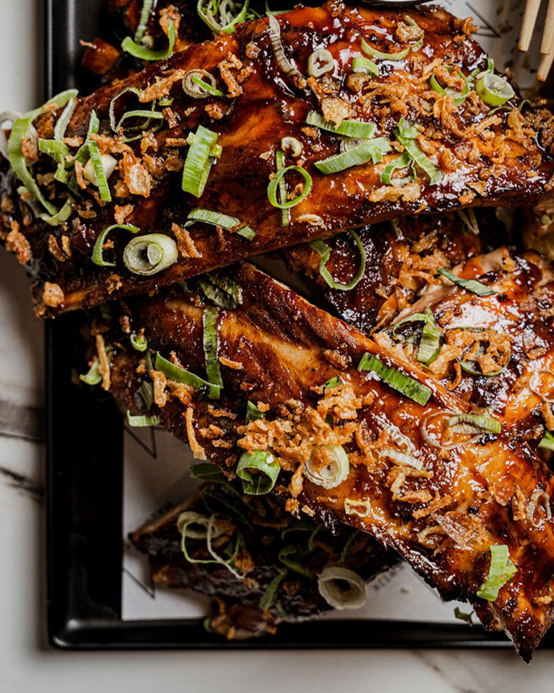 zwart vierkant bord met veel spareribs er op